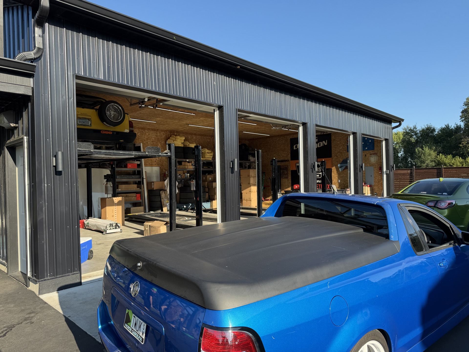 A blue Holden ute parked outside a garage building