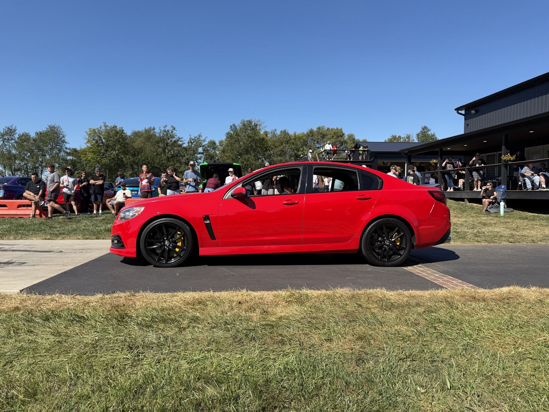 A red HSV GTS-R W1 on display on the grass at the car show